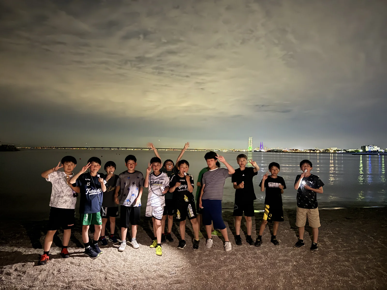 夜の海辺で一緒に過ごす真栄FCの子どもたち