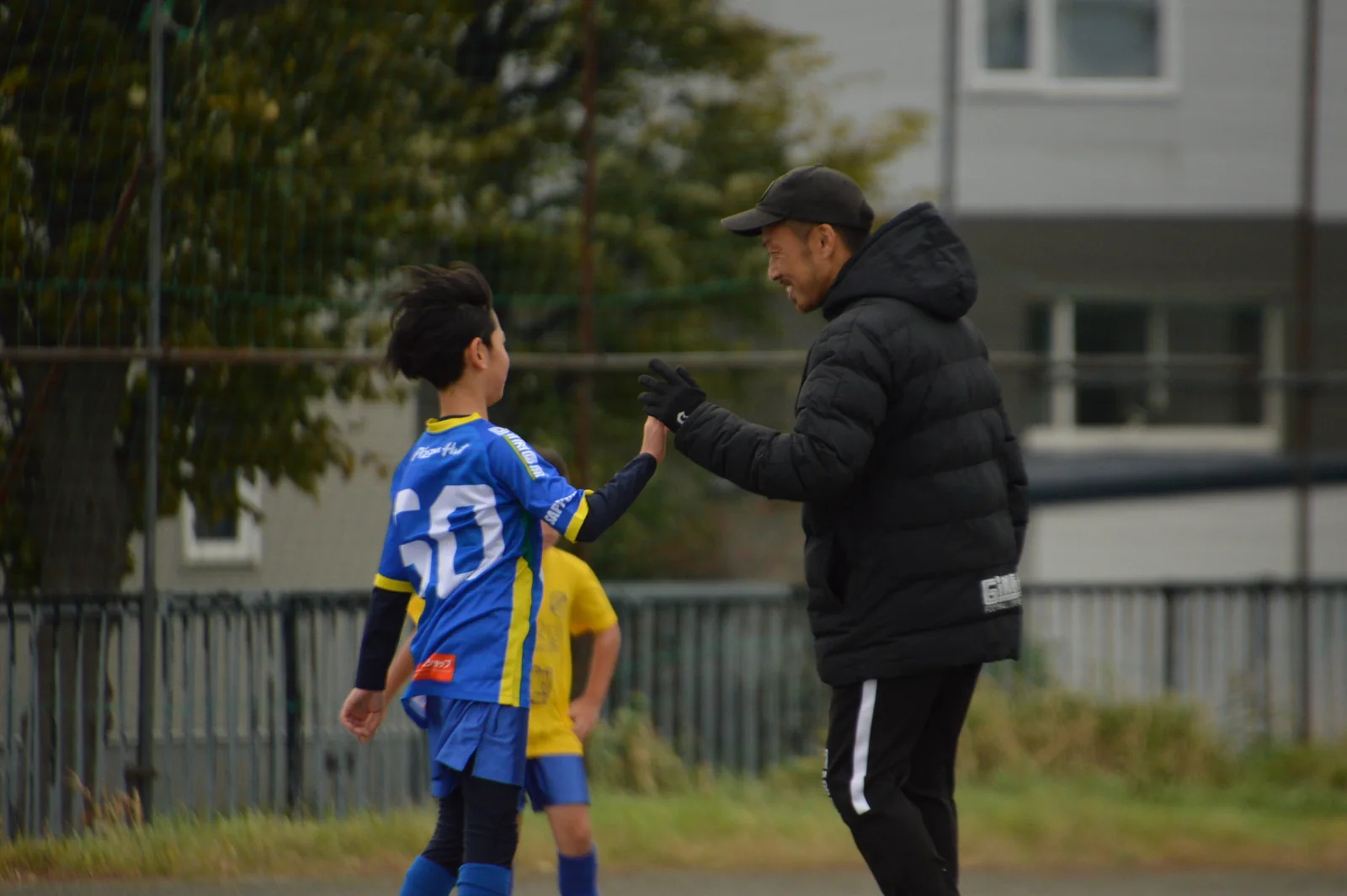 練習で子どもと手を合わせるしおコーチ