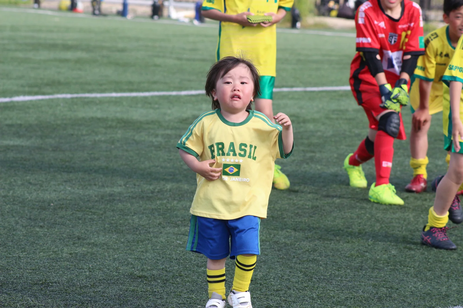 仲間と同じピッチで走る子ども