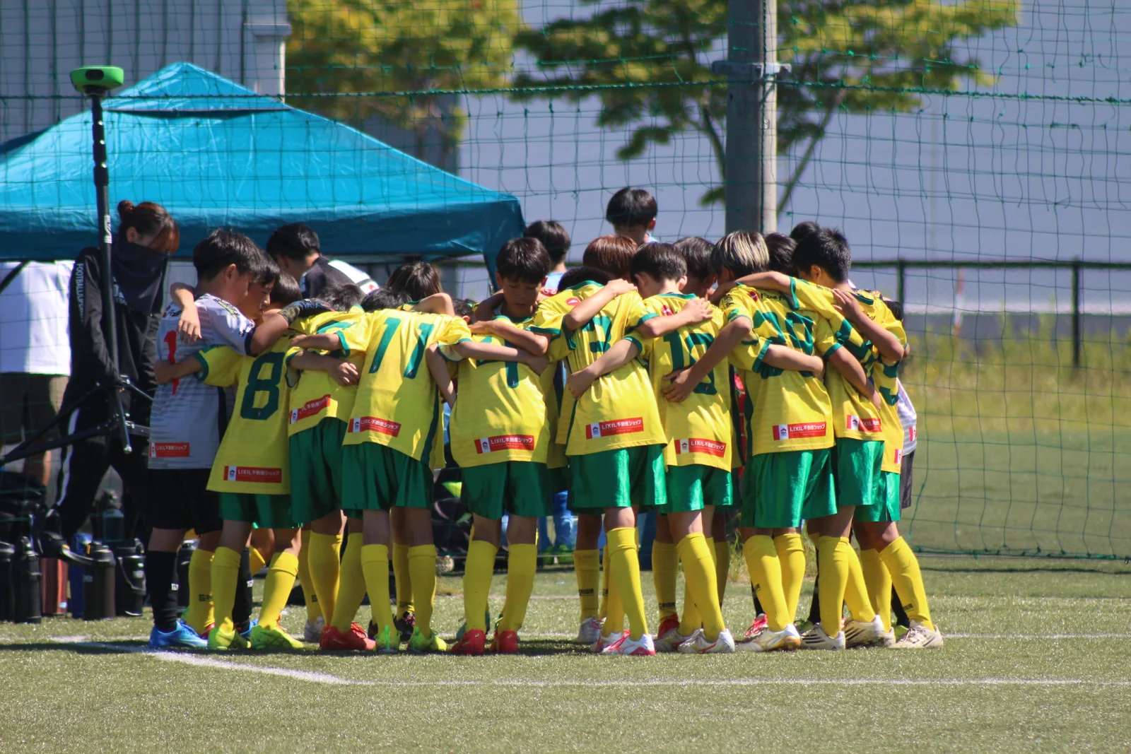肩を組み、円陣をつくる真栄FCの選手たち